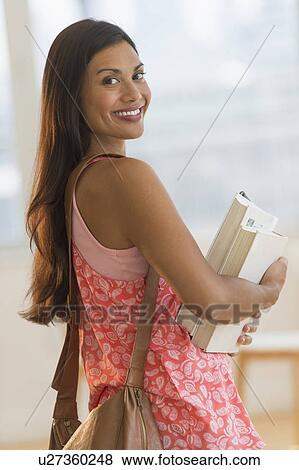 Portrait of female student holding books View Large Photo Image Stock Photo - Portrait of female student holding books. Fotosearch