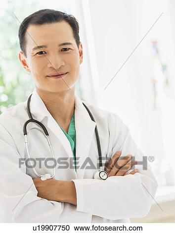 Stock Image - Portrait of happy mid adult doctor. Fotosearch