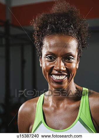 Portrait of happy mid adult woman wearing sports bra View Large Photo Image Stock Image - Portrait of happy mid adult woman wearing sports bra. Fotosearch