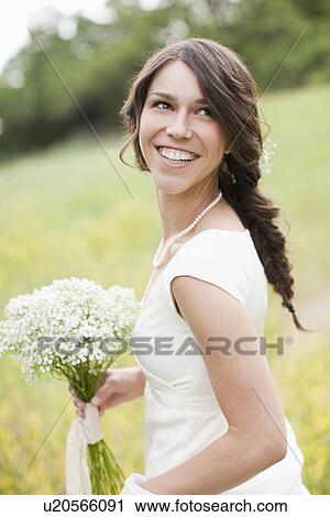 Portrait of happy woman holding flowers and smiling View Large Photo Image Stock Image - Portrait of happy woman holding flowers and smiling. Fotosearch