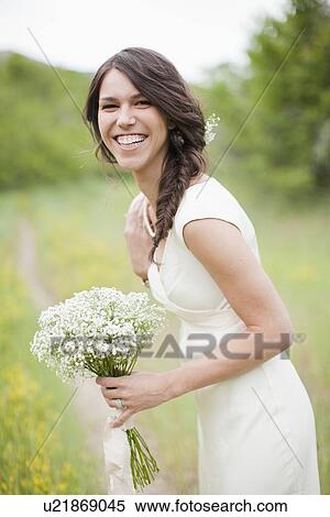 Portrait of happy woman holding flowers and smiling View Large Photo Image Stock Photography - Portrait of happy woman holding flowers and smiling. Fotosearch