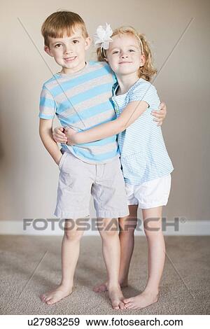 Stock Photo - Portrait of hugging siblings. Fotosearch