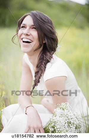 Stock Image - Portrait of laughing woman looking up. Fotosearch