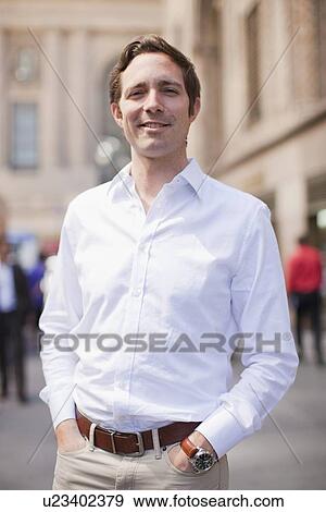 Portrait of man wearing white shirt and holding hands in his pockets View Large Photo Image Stock Photo - Portrait of man wearing white shirt and holding hands in his pockets. Fotosearch