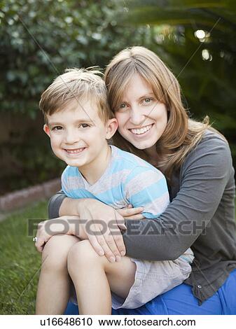 Stock Image - Portrait of mother holding her son (6-7). Fotosearch