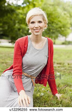 Portrait of sitting and smiling woman in park View Large Photo Image Stock Photography - Portrait of sitting and smiling woman in park. Fotosearch