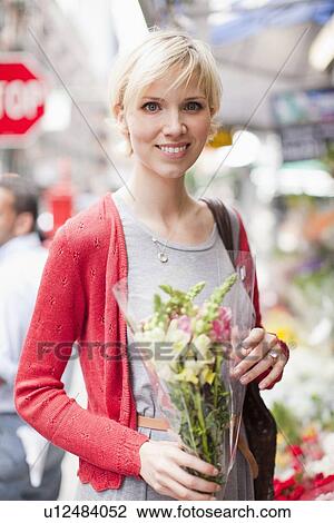 Portrait of smiling woman holding bunch of flowers View Large Photo Image Stock Image - Portrait of smiling woman holding bunch of flowers. Fotosearch