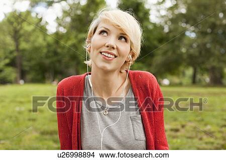Portrait of smiling woman listening to music View Large Photo Image Picture - Portrait of smiling woman listening to music. Fotosearch