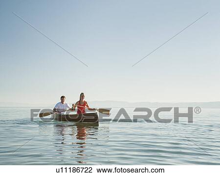 Portrait of two young people paddling canoe View Large Photo Image Stock Image - Portrait of two young people paddling canoe. Fotosearch