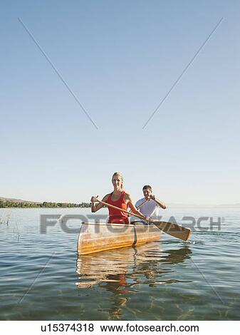 Stock Photo - Portrait of two young people paddling canoe. Fotosearch