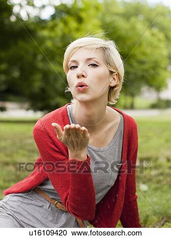 Stock Image - Portrait of woman blowing kiss. Fotosearch