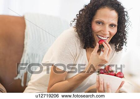 Portrait of woman eating strawberries View Large Photo Image Stock Photograph - Portrait of woman eating strawberries. Fotosearch