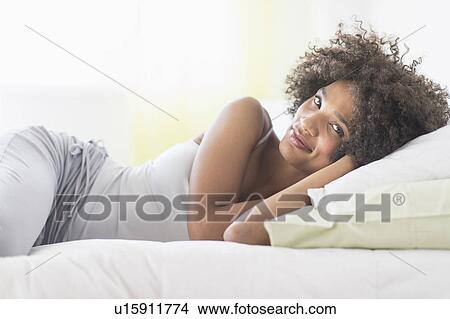 Portrait of woman lying on bed View Large Photo Image Picture - Portrait of woman lying on bed. Fotosearch