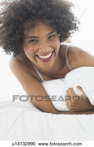 Portrait of woman lying on bed View Large Photo Image Stock Image - Portrait of woman lying on bed. Fotosearch