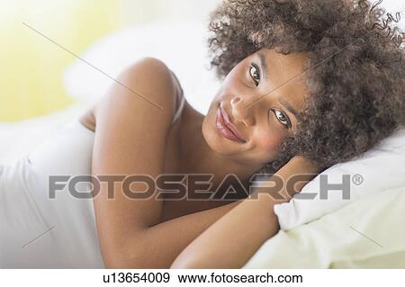 Portrait of woman lying on bed View Large Photo Image Stock Photo - Portrait of woman lying on bed. Fotosearch
