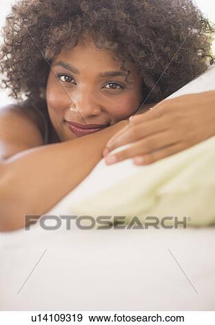 Stock Photo - Portrait of woman lying on bed. Fotosearch