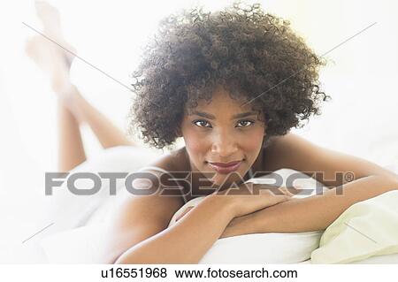 Portrait of woman lying on bed View Large Photo Image Stock Photo - Portrait of woman lying on bed. Fotosearch