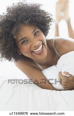 Portrait of woman lying on bed View Large Photo Image Stock Photograph - Portrait of woman lying on bed. Fotosearch
