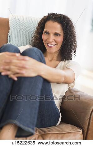 Portrait of woman sitting in living room View Large Photo Image Stock Photography - Portrait of woman sitting in living room. Fotosearch