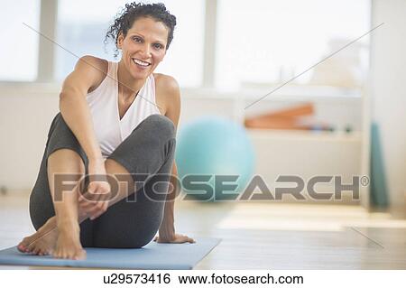 Portrait of woman sitting on exercising mat View Large Photo Image Stock Photograph - Portrait of woman sitting on exercising mat. Fotosearch