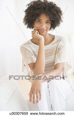 Portrait of woman sitting on sofa View Large Photo Image Stock Photo - Portrait of woman sitting on sofa. Fotosearch