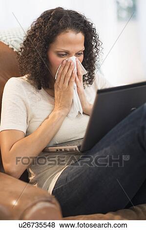 Portrait of woman sitting with laptop and blowing nose View Large Photo Image Stock Photo - Portrait of woman sitting with laptop and blowing nose. Fotosearch