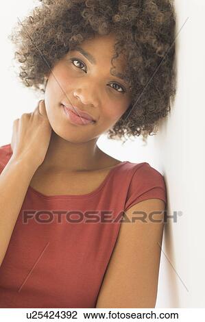 Stock Image - Portrait of woman smiling, studio shot. Fotosearch