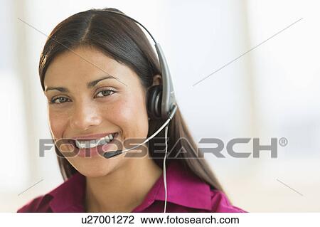 Stock Image - Portrait of woman wearing headset. Fotosearch