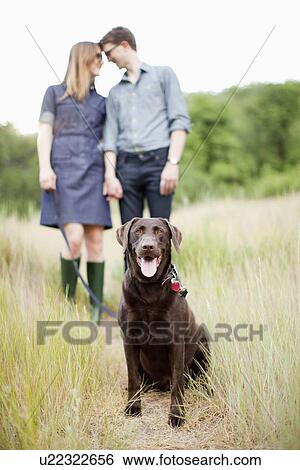 Stock Photograph - Portrait of young couple with dog. Fotosearch