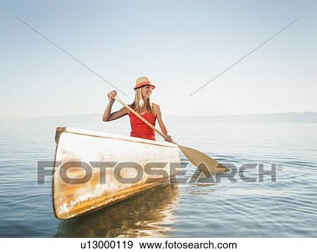 Stock Photo - Portrait of young woman canoe traveling. Fotosearch