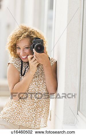 Portrait of young woman holding camera View Large Photo Image Stock Image - Portrait of young woman holding camera. Fotosearch