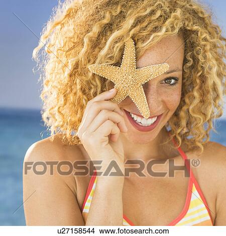 Portrait of young woman holding starfish View Large Photo Image Picture - Portrait of young woman holding starfish. Fotosearch