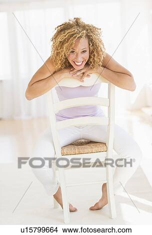 Portrait of young woman leaning on chair View Large Photo Image Picture - Portrait of young woman leaning on chair. Fotosearch