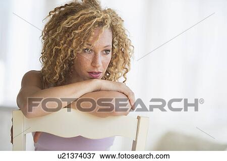 Portrait of young woman leaning on chair View Large Photo Image Stock Photo - Portrait of young woman leaning on chair. Fotosearch