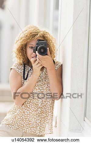 Stock Image - Portrait of young woman photographing. Fotosearch