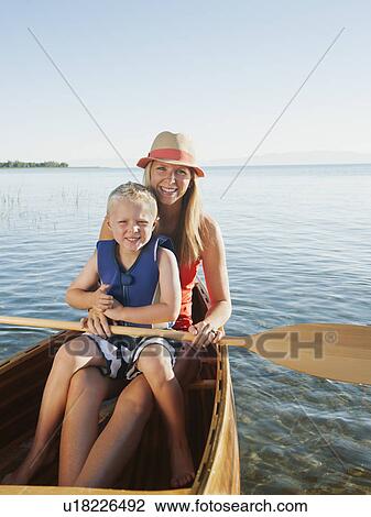 Stock Image - Portrait of young woman with son (4-5) canoe traveling. Fotosearch