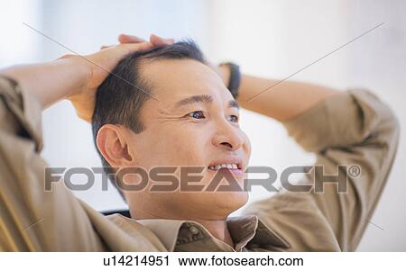 Stock Image - Profile of happy mid adult man with hands behind his back. Fotosearch