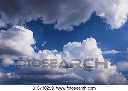 Stock Photo - Puffy clouds on sky. Fotosearch
