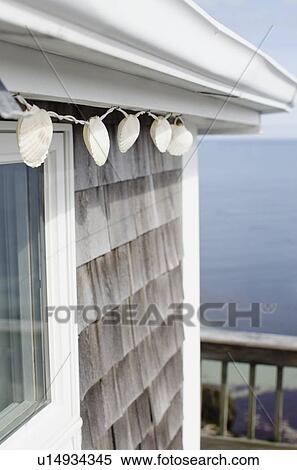 Stock Photography - Shell decoration hanging on summer house on coast. Fotosearch
