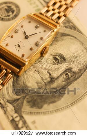 Stock Photo - Studio shot of banknote and gold watch. Fotosearch