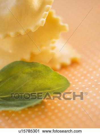 Stock Image - Studio Shot of ravioli and basil leaf. Fotosearch