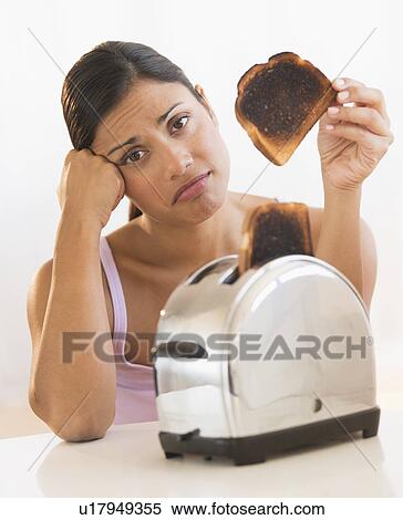 Stock Photography - Studio shot of woman holding burnt toast. Fotosearch