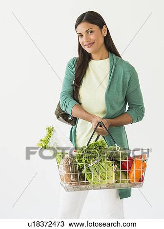 Studio shot of woman holding shopping basket with vegetables View Large Photo Image Stock Image - Studio shot of woman holding shopping basket with vegetables. Fotosearch