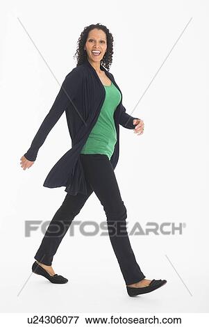 Stock Photo - Studio shot of woman walking. Fotosearch