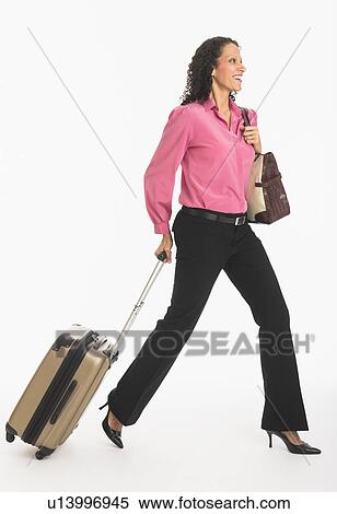 Studio shot of woman walking with suitcase View Large Photo Image Stock Photography - Studio shot of woman walking with suitcase. Fotosearch