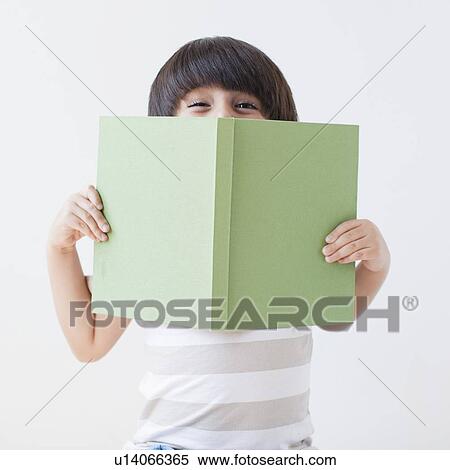 Stock Photography - Studio Shot of young boy holding book. Fotosearch