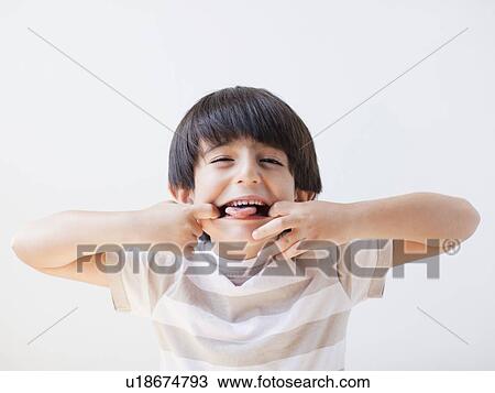 Studio Shot of young boy making grimace View Large Photo Image Stock Image - Studio Shot of young boy making grimace. Fotosearch