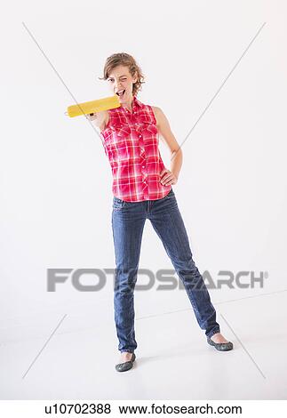 Studio shot of young woman holding paint roller View Large Photo Image Stock Photo - Studio shot of young woman holding paint roller. Fotosearch