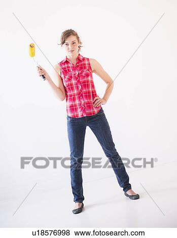 Studio shot of young woman holding paint roller View Large Photo Image Stock Photo - Studio shot of young woman holding paint roller. Fotosearch