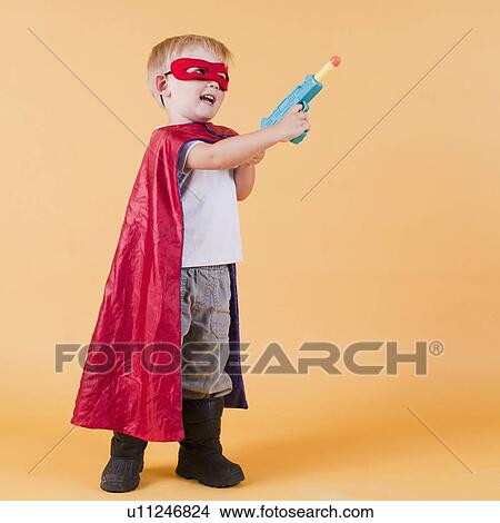 Studio shot, Portrait of boy (2-5 years) wearing cape and holding toy gun View Large Photo Image Picture - Studio shot, Portrait of boy (2-5 years) wearing cape and holding toy gun. Fotosearch